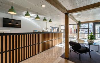 Lichte ontvangsthal met moderne houten balie en comfortabele zitruimte in het kantoorpand aan Lange Dreef 10, Vianen Utr. Ideale locatie voor kantoorruimte huren met een professionele uitstraling.