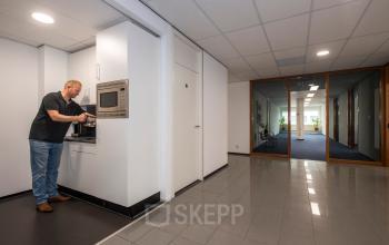 Kantoorpand aan Witboom 1 in Vianen Utr met man die koffie zet in een pantry. Zakelijke kantoorruimte huren met moderne voorzieningen.