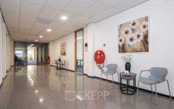 Binnenkant van een modern kantoorpand op Witboom 1, Vianen Utr met marmeren vloer, stoelen en kunstwerken aan de wand. Belangrijk voor bedrijven die kantoorruimte willen huren.