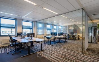 Moderne kantoorruimte te huur aan Lange Dreef 17, Vianen Utr, met glazen wanden en werkplekken voorzien van bureaus en draaistoelen.
