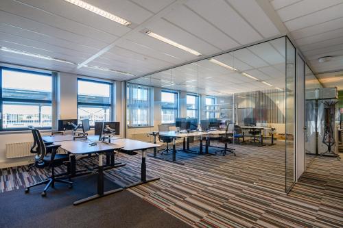 Moderne kantoorruimte te huur aan Lange Dreef 17, Vianen Utr, met glazen wanden en werkplekken voorzien van bureaus en draaistoelen.