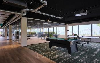 Moderne kantoorruimte op Havenweg 24 in Vianen Utr met stijlvolle inrichting, inclusief biljarttafel en uitzicht op een open werkvloer. Ideaal voor het huren van kantoren in een dynamisch kantoorpand.