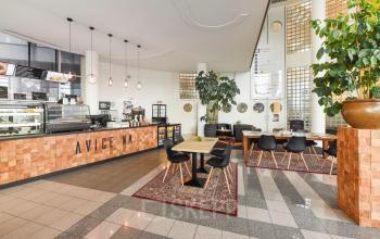 Lichte, gemeubileerde kantoorruimte op Regulusweg 11 in Voorburg met moderne inrichting, tafels en stoelen, geschikt voor werk of vergaderingen. Geschikt voor kantoorruimte huren.