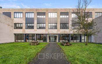 Vooraanzicht van kantoorpand aan Agro Business Park 22 in Wageningen met praktische uitstraling en groene grasvelden. Ideaal voor wie kantoorruimte wil huren in een functioneel ingericht pand.