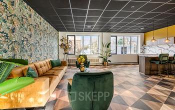 Lichte kantoorruimte in Wageningen met stijlvolle inrichting, inclusief bank, planten en marmeren aanrechtblad. Ideaal voor huren op Agro Business Park 22.