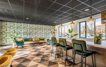 Stijlvolle kantoorruimte met kleurrijke muren en moderne meubels op Agro Business Park 22 in Wageningen. Ideaal voor wie een kantoorpand wil huren. Planten zorgen voor een aangename sfeer.