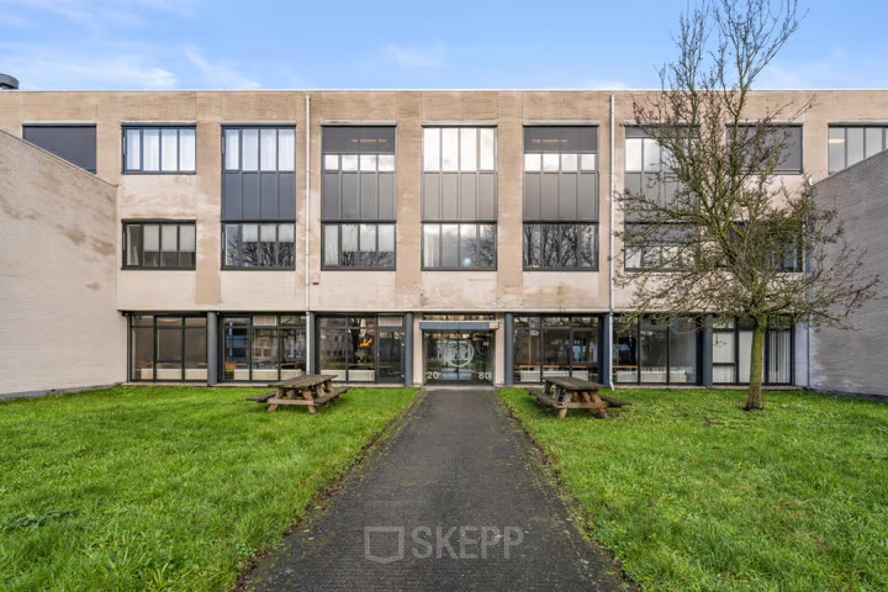 Vooraanzicht van kantoorpand aan Agro Business Park 22 in Wageningen met praktische uitstraling en groene grasvelden. Ideaal voor wie kantoorruimte wil huren in een functioneel ingericht pand.