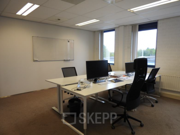 Kantoorruimte huren in kantoorpand gelegen aan Pompmolenlaan 9, Woerden, met werkplekken aan bureaus, computerschermen en stoelen bij de ramen.