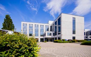 Moderne kantoorpand op Pelmolenlaan 16 in Woerden met strakke gevels en ruime parkeerplaats, ideaal voor kantoorruimte huren.