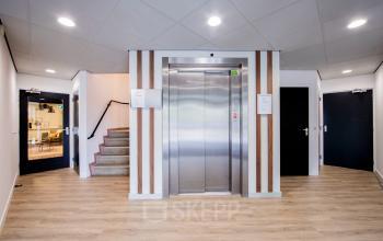 Ingang van het kantoorpand op Pelmolenlaan 16, Woerden, met een strakke lift en moderne afwerking, ideaal voor kantoren en zakelijke doeleinden.