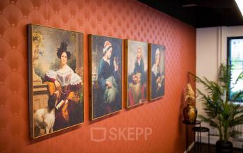 Kantoorruimte op Pelmolenlaan 16 in Woerden met kunstwerken aan een warme oranje muur. Open en professioneel ingericht, ideaal voor zakelijke activiteiten. Huren van dit kantoorpand biedt een inspirerende omgeving.