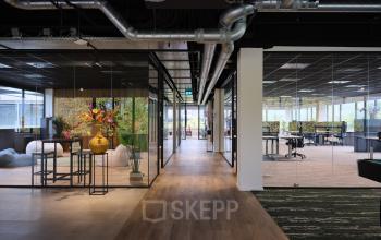 Moderne kantoorpand op Vijzelmolenlaan 9 in Woerden met glazen wanden, houten vloeren en planten voor een frisse uitstraling. Ideale kantoorruimte huren voor een professionele werkomgeving.