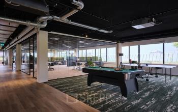 Moderne, ruime kantoorruimte op Vijzelmolenlaan 9, Woerden, met glazen wanden, pooltafel en uitzicht naar buiten; perfect voor bedrijven die kantoorruimte willen huren.