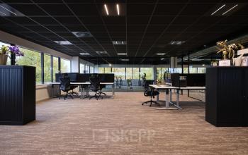 Moderne kantoorruimte met bureaus en stoelen, ruime indeling en grote ramen aan de Vijzelmolenlaan 9 in Woerden. Perfect voor wie kantoren wil huren in een dynamische omgeving.