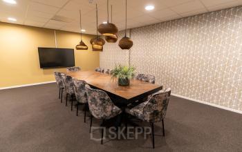 Kantoorruimte huren in Woerden op Vijzelmolenlaan 9 met een stijlvolle vergaderruimte voorzien van grote houten tafel en comfortabele stoelen, perfect voor bijeenkomsten en overleg.