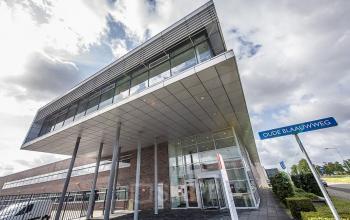 Uitzicht op het moderne kantoorpand aan Oude Blaauwweg 5, Wormerveer, ideaal om te huren. Het pand heeft een stijlvolle glazen voorgevel en een uitnodigende entree.