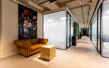Moderne kantoorruimte op Boerhaavelaan 40, Zoetermeer, met glazen wanden, oranje leren bank en planten. Ideaal om als kantoor of kantoorpand te huren.
