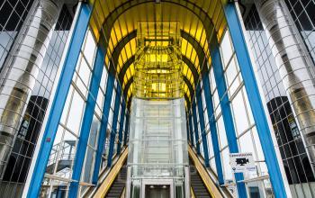 Ingang van kantoorpand Boerhaavelaan 40 in Zoetermeer met glazen gevel, roltrappen en lift.