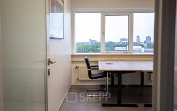 Kantoorruimte te huur op Boerhaavelaan 40, Zoetermeer. Smaakvol ingericht kantoor met twee bureaustoelen en een groot raam met uitzicht over de stad.