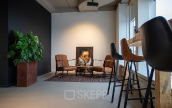 Moderne kantoorruimte op Boerhaavelaan 40 in Zoetermeer met comfortabele stoelen en een opvallend schilderij. Ideaal voor creatieve inspiratie of vergaderingen.