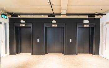 Kantoorpand Boerhaavelaan 40 in Zoetermeer met drie zwarte liften en neutrale muren, ideaal voor kantoorruimte huren.