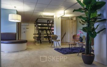 Modern ingerichte ontvangstruimte in kantoorpand op Bredewater 26 in Zoetermeer met comfortabele zitjes en stijlvolle decoratie.