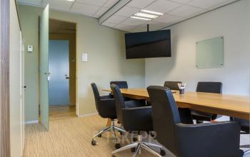 Vergaderruimte in het kantoorpand op Bredewater 26, Zoetermeer, met een lange tafel, comfortabele stoelen en presentatiescherm. Kantoorruimte huren met een professionele uitstraling voor zakelijke besprekingen en vergaderingen.