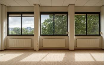 Lichte kantoorruimte met grote ramen op Bredewater 26 in Zoetermeer. Uitzicht op groene omgeving en gebouwen. Perfecte locatie om een kantoor te huren in een kantoorpand.