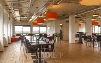 Ruime en lichte kantoorruimte in Zoetermeer met moderne inrichting en grote ramen, geschikt voor werk of vergaderingen. Ideaal voor kantoorruimte huren in een inspirerende omgeving.