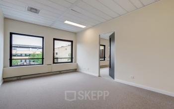 Lichte kantoorruimte te huur op Edelgasstraat 101 in Zoetermeer met grote ramen en neutrale muren, perfect voor een inspirerende werkplek.