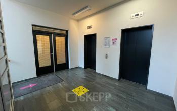 Entree van een kantoorpand met twee liften en een deur, geschikt voor kantoorruimte huren in Zoetermeer aan de Baron de Coubertinlaan 35.