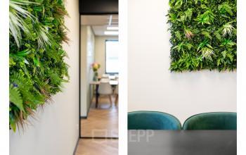 Moderne kantoorruimte huren met groene wanddecoratie, zicht op gemeubileerde vergaderruimte aan Stationsplein 4, Zwijndrecht.