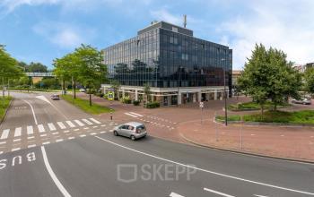 Modern kantoorpand op Stationsplein 4, Zwijndrecht, met grote glaspartijen en een stedelijke omgeving. Ideaal voor kantoorruimte huren dicht bij voorzieningen en openbaar vervoer.