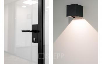 Moderne deurklink en minimalistische wandlamp in een kantoorruimte op Stationsplein 4, Zwijndrecht. Ideale plek om kantoorruimte te huren met aandacht voor stijl en functionaliteit.