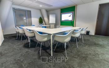 Moderne vergaderruimte met een grote tafel en stoelen bij Grote Voort 293 in Zwolle, geschikt voor kantoorruimte huren.