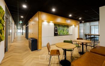 Moderne kantoorruimte huren op Zuiderzeelaan 27-41 in Zwolle met stijlvolle inrichting, inclusief houten vloer, plantenwand en comfortabele zitjes.