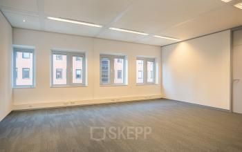 Leeg kantoorpand op Zuiderzeelaan 27-41 in Zwolle met vier grote ramen en tapijt, ideaal voor bedrijven die kantoorruimte willen huren.