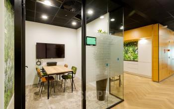 Moderne vergaderruimte met glazen wanden, houten tafel en stoelen in kantoorpand op Zuiderzeelaan 27-41, Zwolle.