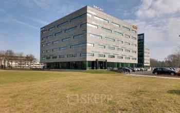 Exterieur van een modern kantoorpand op Zwartewaterallee 48 in Zwolle, met omliggende parkeerplaatsen en grasveld. Ideaal voor kantoorruimte huren in een zakelijke omgeving.