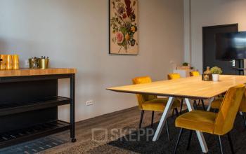 Modern ingerichte werkruimte in het kantoorpand op Zwartewaterallee 48, Zwolle met houten tafel en gele stoelen. Perfect voor kantoorruimte huren.