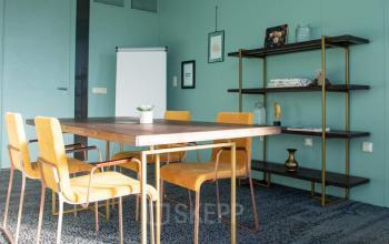 Stijlvolle kantoorruimte met gele stoelen en houten tafel, ideaal om te huren in kantoorpand Zwartewaterallee 48, Zwolle.