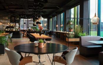 Moderne kantoorruimte met houten vloeren, grote ramen en stijlvolle meubels op Zwartewaterallee 48, perfect om te huren voor een inspirerende werkomgeving.