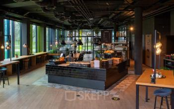 Moderne kantoorruimte op Zwartewaterallee 48, Zwolle, met een stijlvolle, gemeubileerde inrichting en grote ramen die veel licht binnenlaten. Een uitnodigende ruimte voor diverse zakelijke activiteiten zoals werk en vergaderingen.