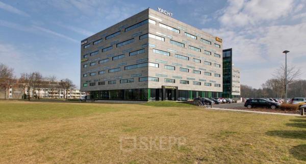 Exterieur van een modern kantoorpand op Zwartewaterallee 48 in Zwolle, met omliggende parkeerplaatsen en grasveld. Ideaal voor kantoorruimte huren in een zakelijke omgeving.