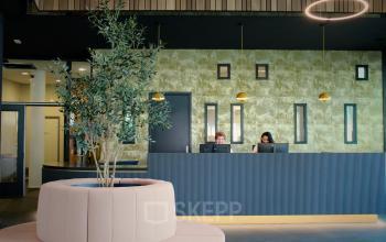 Receptieruimte in kantoorpand aan Zwartewaterallee 56 in Zwolle met twee medewerkers achter de balie.