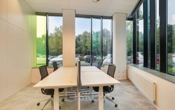 Kantoorruimte huren in Zwolle aan Zwartewaterallee 56, met grote ramen die natuurlijk licht binnenlaten. Het interieur is functioneel ingericht met werkplekken en bureaustoelen.