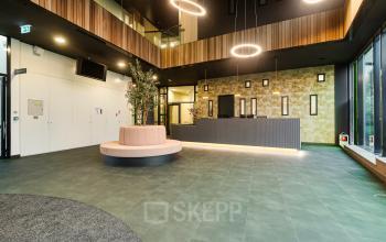 Moderne receptie met een elegante balie en hoogwaardige afwerking in het kantoorpand aan de Zwartewaterallee 56 in Zwolle, ideaal voor zakelijke huur.
