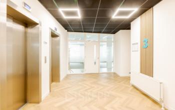 De lichte hal in het kantoorpand aan de Zuiderzeelaan 15-25 in Zwolle toont een modern interieur met lift en doorgang naar kantoorruimtes. Geschikt voor bedrijven die kantoorruimte willen huren.