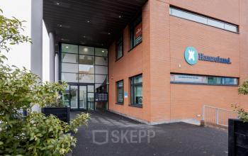 Entree van kantoorpand op Zuiderzeelaan 15-25 in Zwolle, met opvallende glazen facade en moderne architectuur. Ideaal voor wie kantoorruimte wil huren in een professionele omgeving.