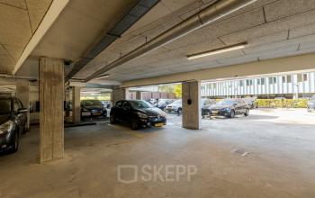 Overdekte parkeergarage op Zuiderzeelaan 15-25 in Zwolle, geschikt voor kantoorruimte huren met diverse geparkeerde auto's onder een betonnen plafond.